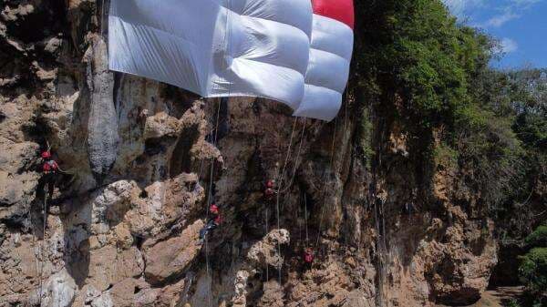 4 Atlet Panjat Tebing Muda Kibarkan Merah Putih Raksasa di Bukit Lembah Kera Malang
