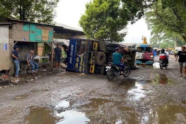 Melintas Jalan Berlubang, Truk Pangangkut Kayu Terguling di Sukabumi